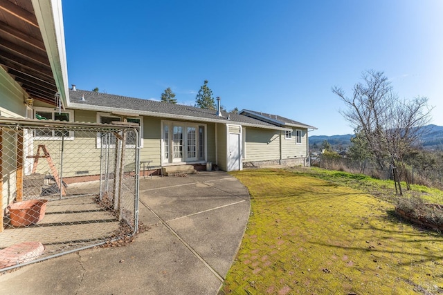 view of front facade with a patio area, a mountain view, and a front yard