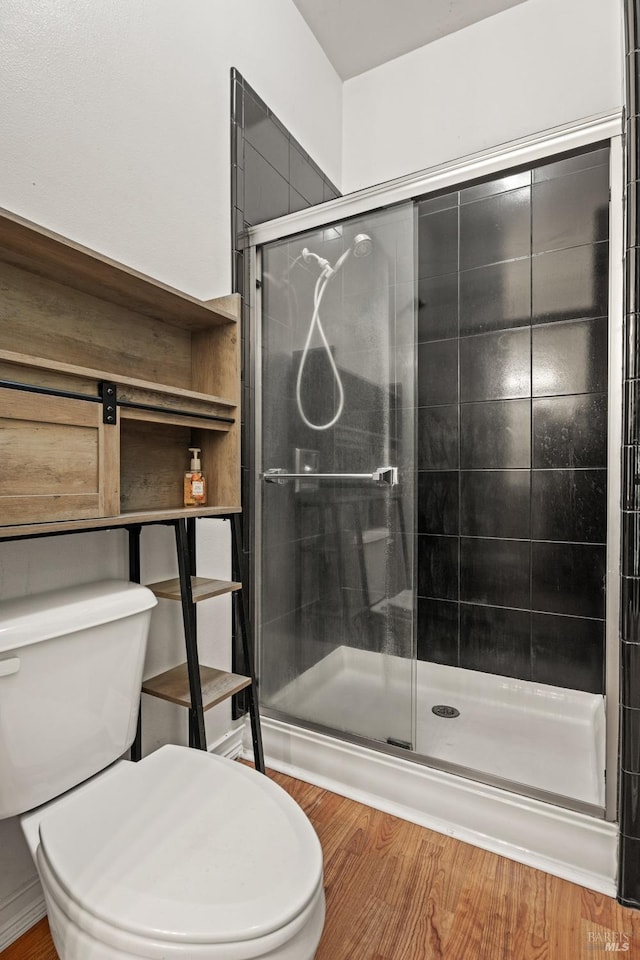 full bathroom featuring a shower stall and toilet