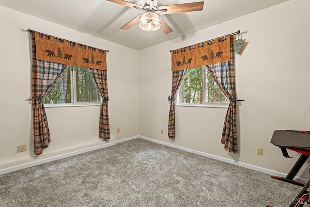 unfurnished room with carpet floors, baseboards, and a ceiling fan