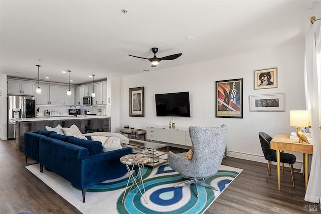 living room featuring ceiling fan, dark hardwood / wood-style floors, and sink