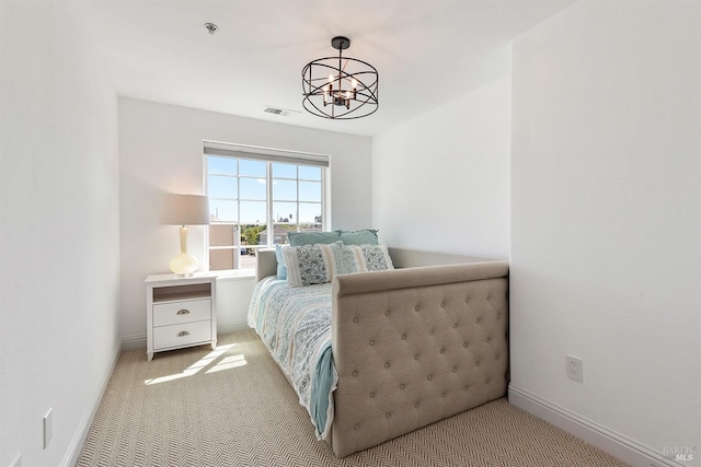 carpeted bedroom with an inviting chandelier