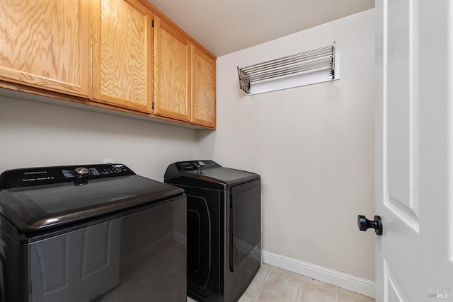 laundry room featuring independent washer and dryer, cabinets, and a textured ceiling