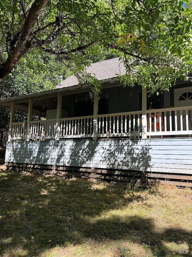 view of front facade featuring a wooden deck and a front yard