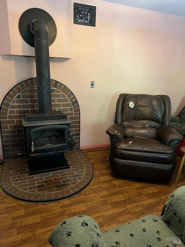 living room featuring dark hardwood / wood-style floors and a wood stove