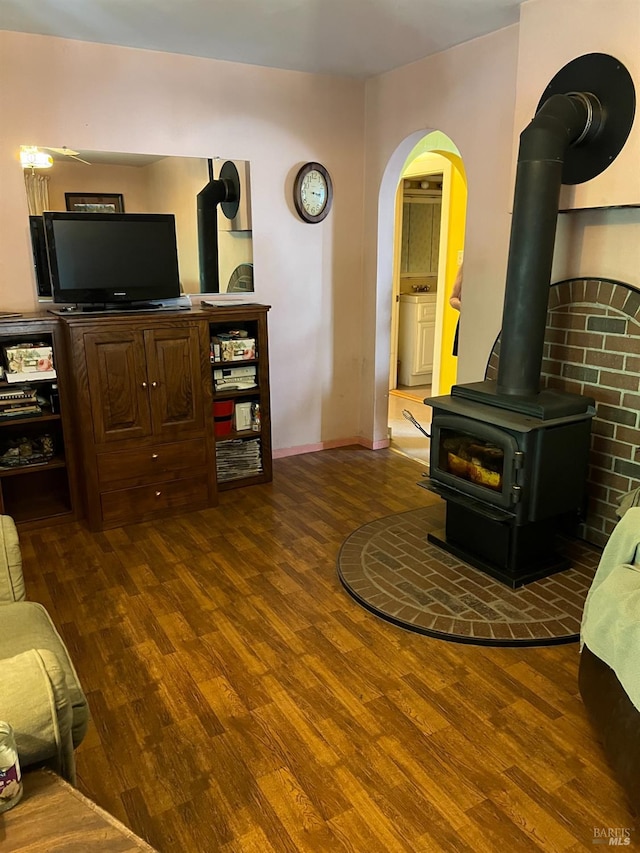 living room with dark hardwood / wood-style floors and a wood stove