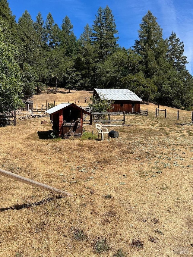 view of yard featuring an outdoor structure and a rural view