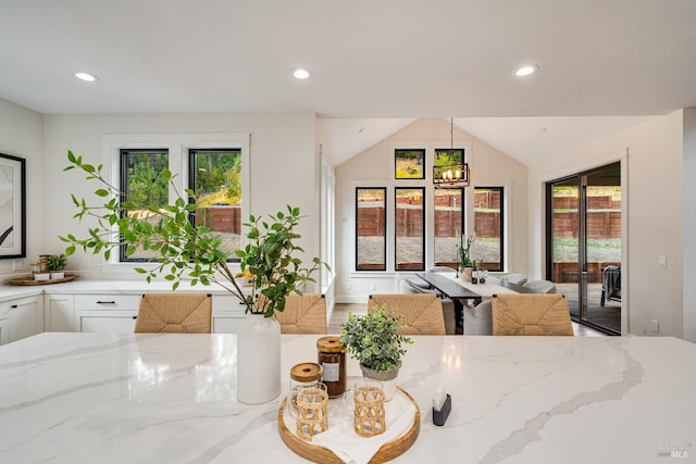 dining space featuring wood-type flooring, a notable chandelier, and vaulted ceiling