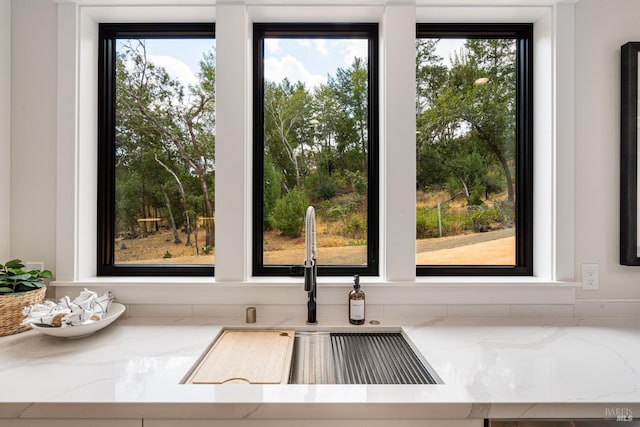 interior space featuring light stone counters and sink