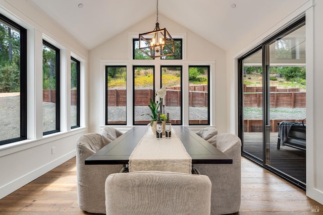 sunroom / solarium featuring vaulted ceiling and a chandelier