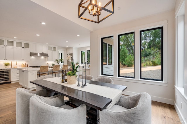 dining area featuring plenty of natural light, wine cooler, and light hardwood / wood-style floors