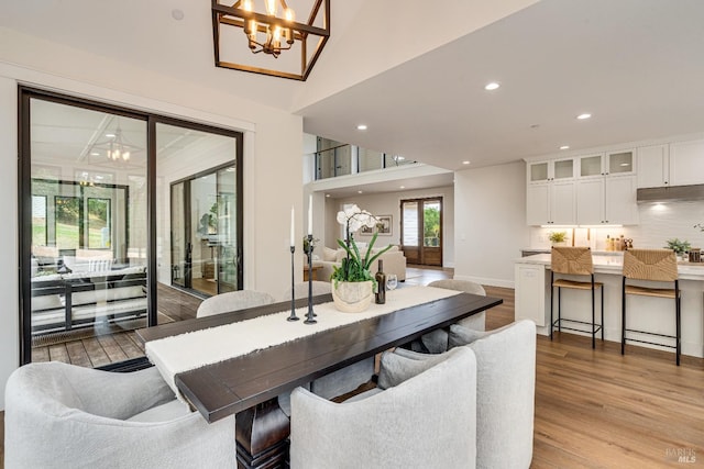 dining space featuring light hardwood / wood-style flooring and an inviting chandelier