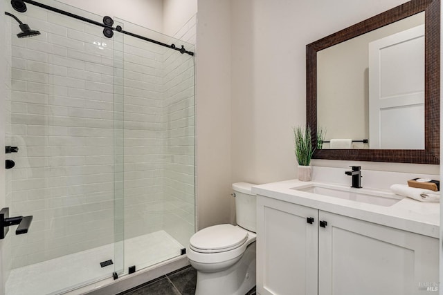 bathroom featuring tile patterned flooring, vanity, toilet, and a shower with shower door