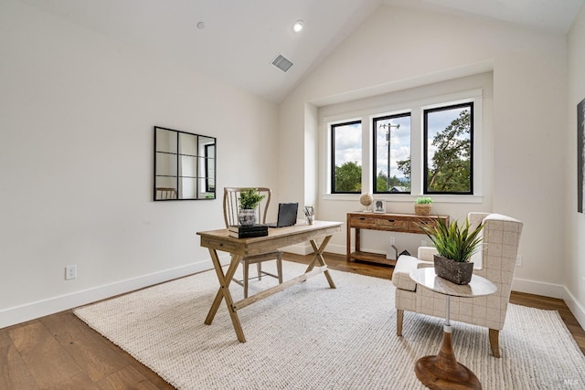 home office with vaulted ceiling and hardwood / wood-style floors