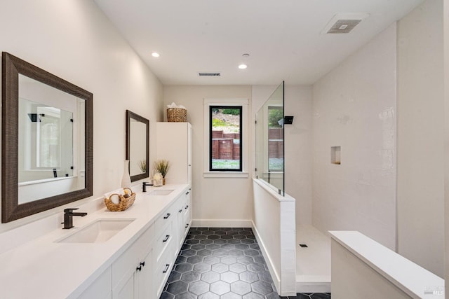 bathroom featuring vanity, a shower, and tile patterned floors