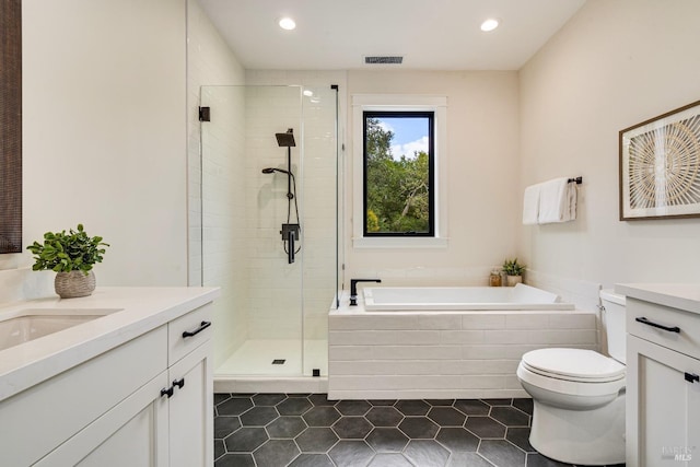 full bathroom with vanity, toilet, plus walk in shower, and tile patterned flooring