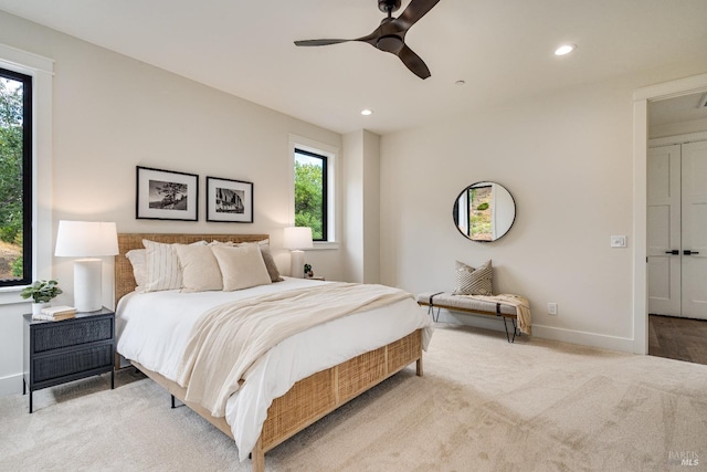 bedroom with multiple windows, light colored carpet, and ceiling fan