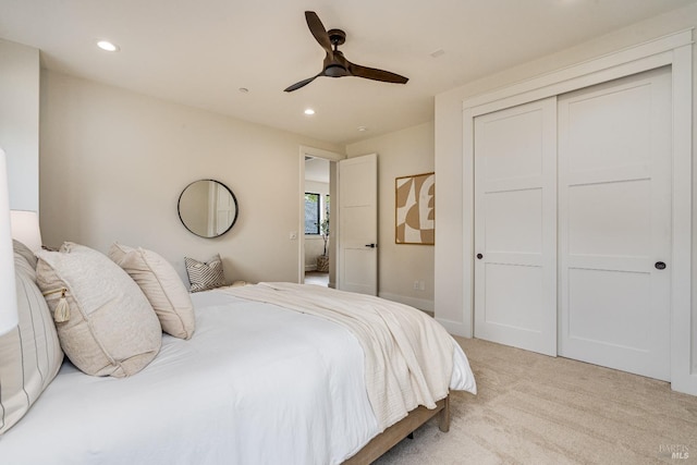 bedroom featuring a closet, ceiling fan, and light carpet