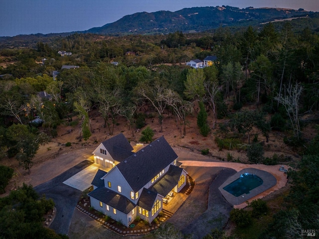 aerial view at dusk featuring a mountain view