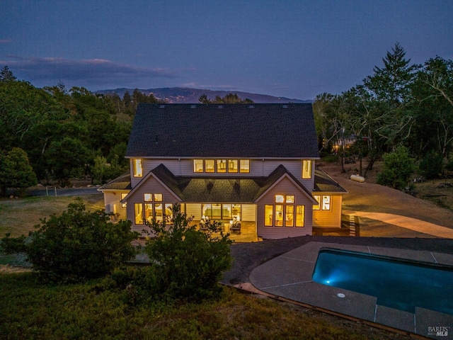 back house at dusk featuring french doors and a patio area