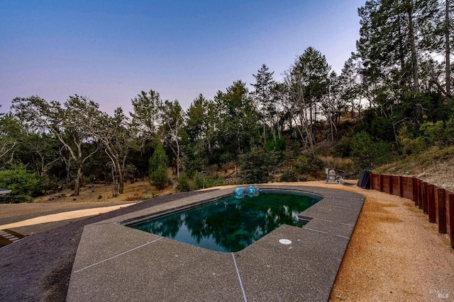 pool at dusk with a patio