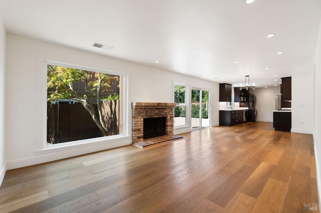 unfurnished living room featuring light wood-type flooring, visible vents, baseboards, and recessed lighting