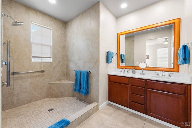 bathroom featuring vanity, a wealth of natural light, tile patterned floors, and tiled shower