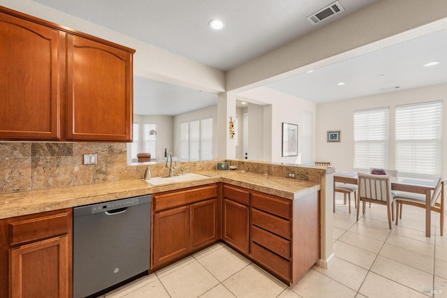 kitchen with kitchen peninsula, dishwasher, a healthy amount of sunlight, and sink