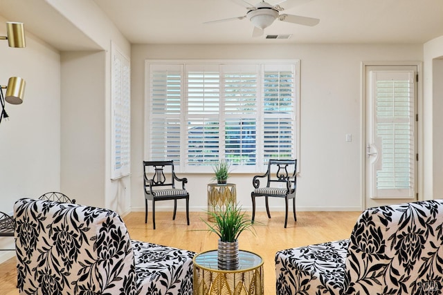 living room with light wood-type flooring and ceiling fan