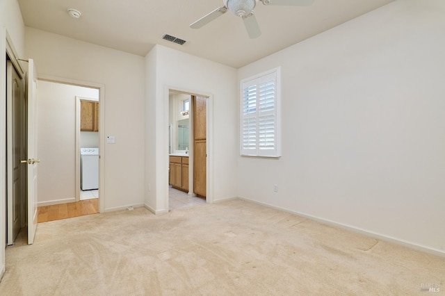 unfurnished bedroom featuring washer / clothes dryer, ceiling fan, and light colored carpet