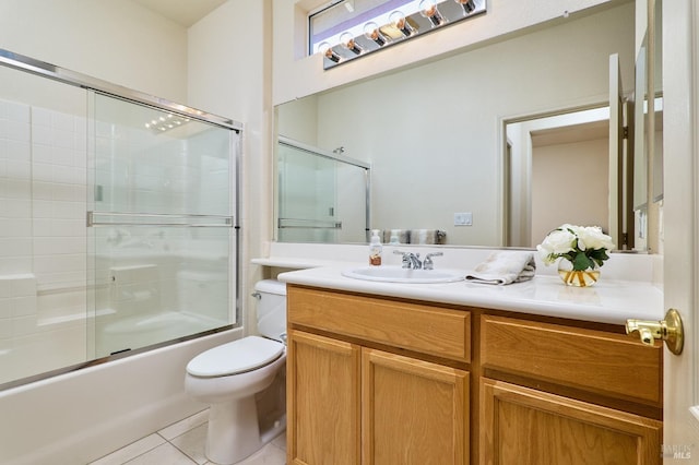 full bathroom featuring tile patterned flooring, toilet, bath / shower combo with glass door, and vanity