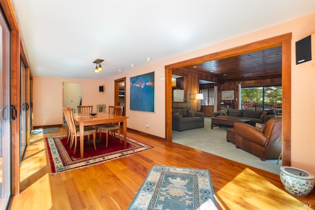 dining room featuring wooden walls and light hardwood / wood-style flooring