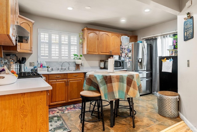 kitchen with appliances with stainless steel finishes, extractor fan, and sink