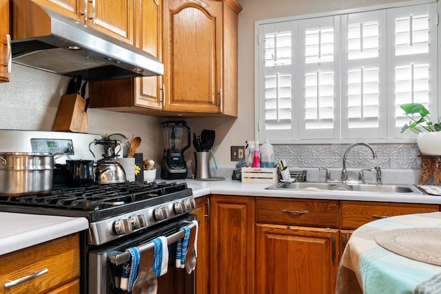 kitchen featuring backsplash, stainless steel range with gas cooktop, and sink