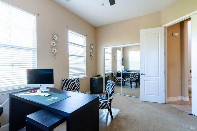 carpeted home office featuring ceiling fan