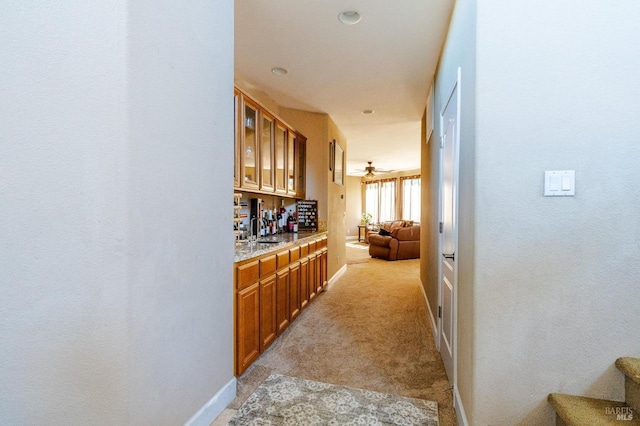 corridor with light colored carpet and sink