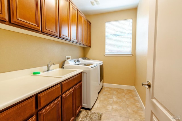 laundry area with cabinets, independent washer and dryer, light tile patterned flooring, and sink