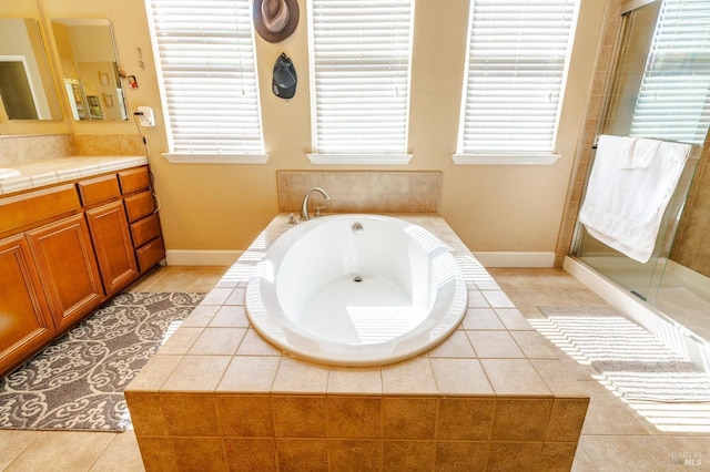 bathroom featuring tile patterned flooring, shower with separate bathtub, and vanity