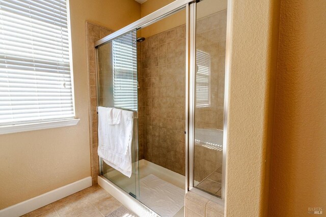 bathroom featuring tile patterned floors and a shower with door