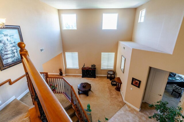 staircase featuring tile patterned flooring and a towering ceiling