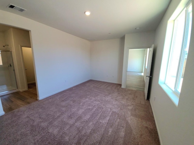 spare room featuring carpet, visible vents, and baseboards