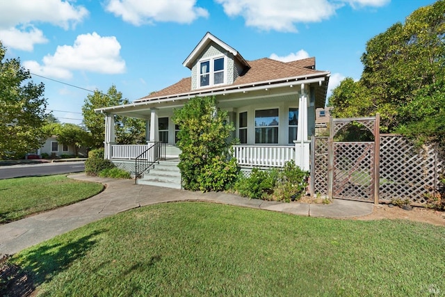 view of front of property featuring a front yard and covered porch