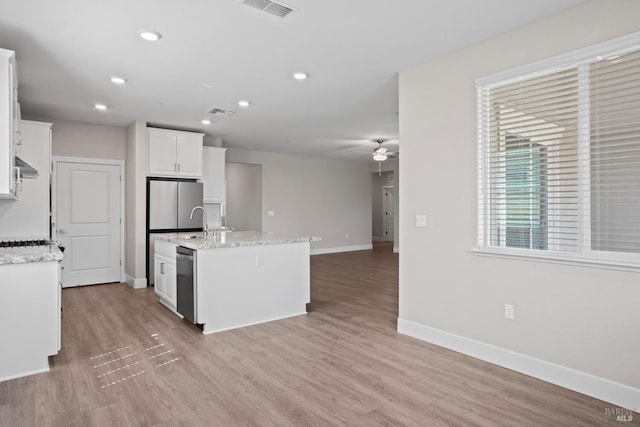 kitchen featuring a wealth of natural light, appliances with stainless steel finishes, ceiling fan, and a kitchen island with sink