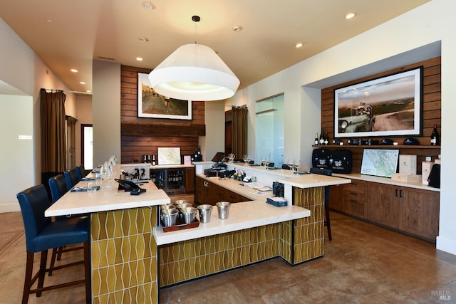 kitchen with visible vents, a breakfast bar, light countertops, a large island with sink, and recessed lighting