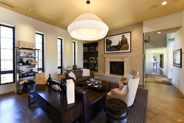 living area featuring a large fireplace, baseboards, visible vents, and recessed lighting