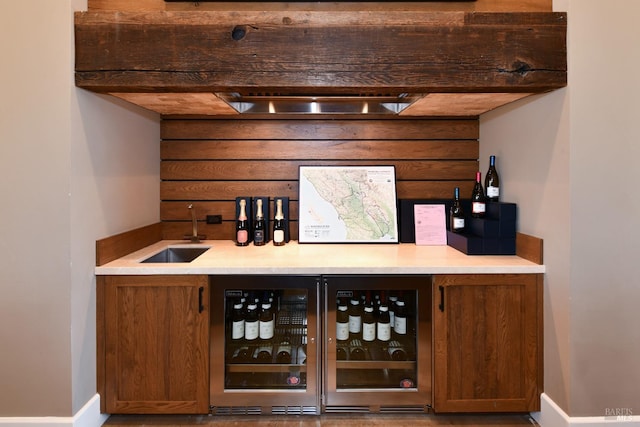 bar featuring wine cooler, indoor wet bar, a sink, and wooden walls