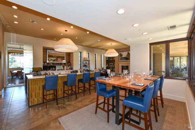 dining room with visible vents, a fireplace, baseboards, and recessed lighting