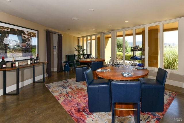 dining area featuring recessed lighting, finished concrete floors, and baseboards