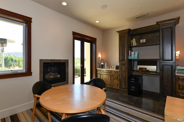 dining space with recessed lighting, visible vents, baseboards, french doors, and a tiled fireplace