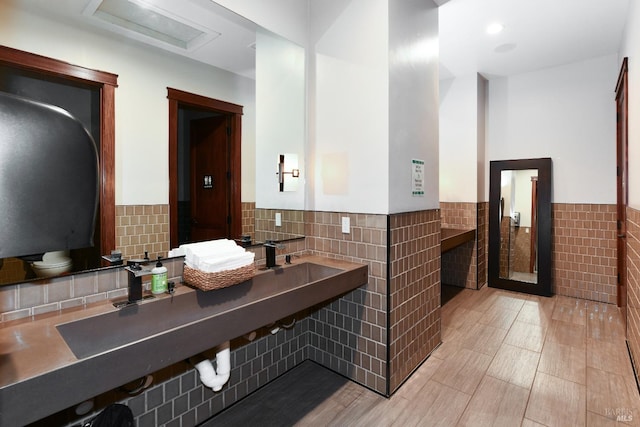 bathroom featuring a wainscoted wall and tile walls