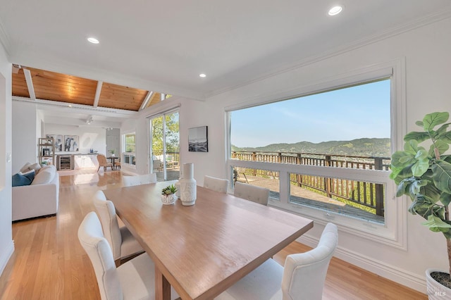 dining room featuring wood ceiling, crown molding, a mountain view, and light hardwood / wood-style floors